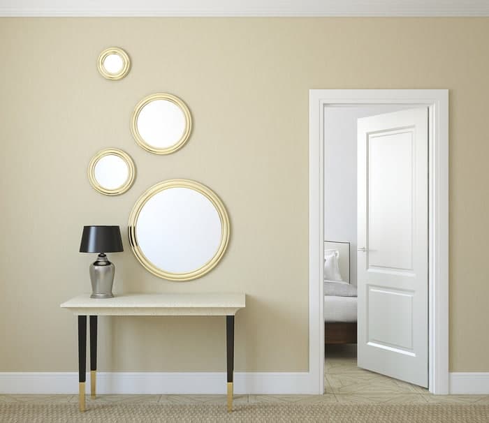Large and small round home mirrors decorate interior hallway
