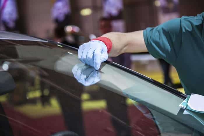 Auto glass specialists repairs rock chips in a vehicle's windshield