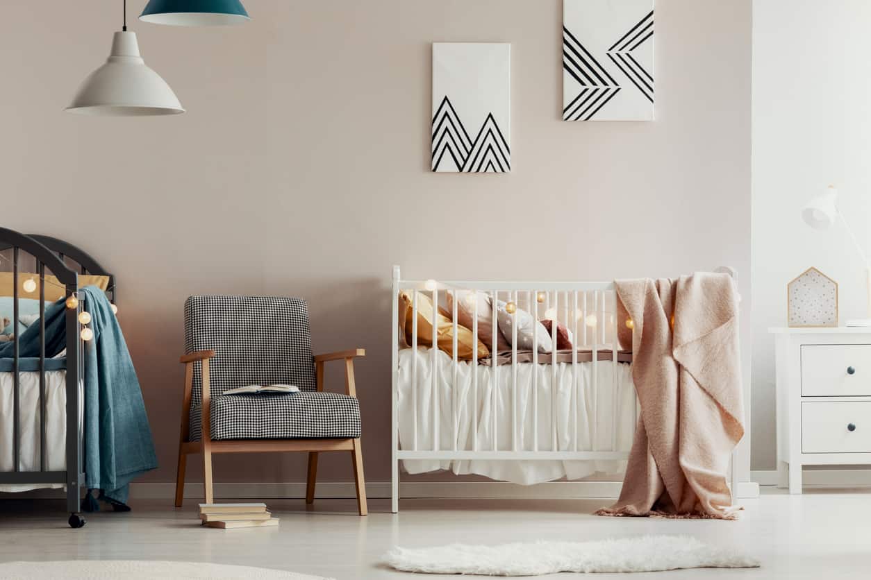 Greige nursery with retro modern paintings and a retro armchair