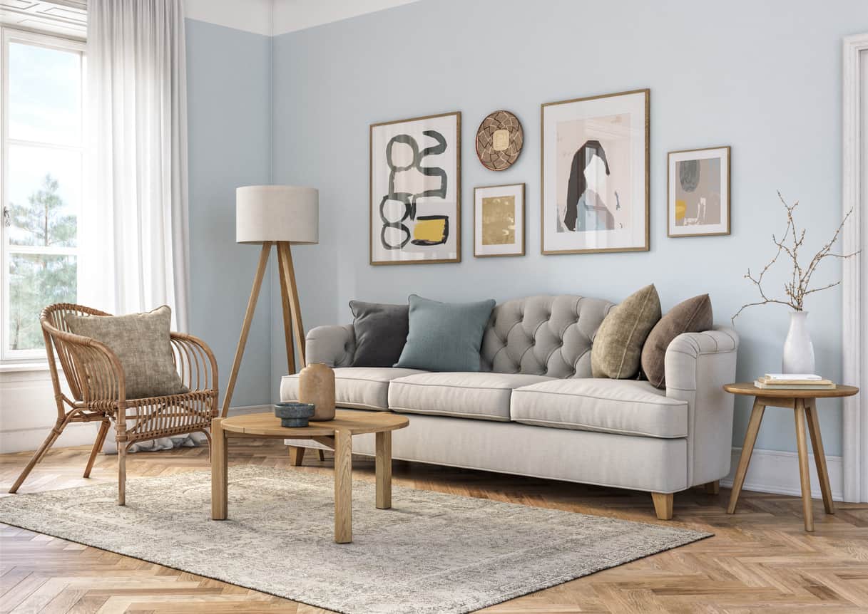 living room with light blue paint and natural wood and cream couch and design elements