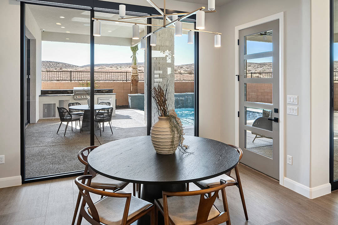 Beautiful dining room in home in St. George Utah with multi-slide patio doors going out to outdoor living area
