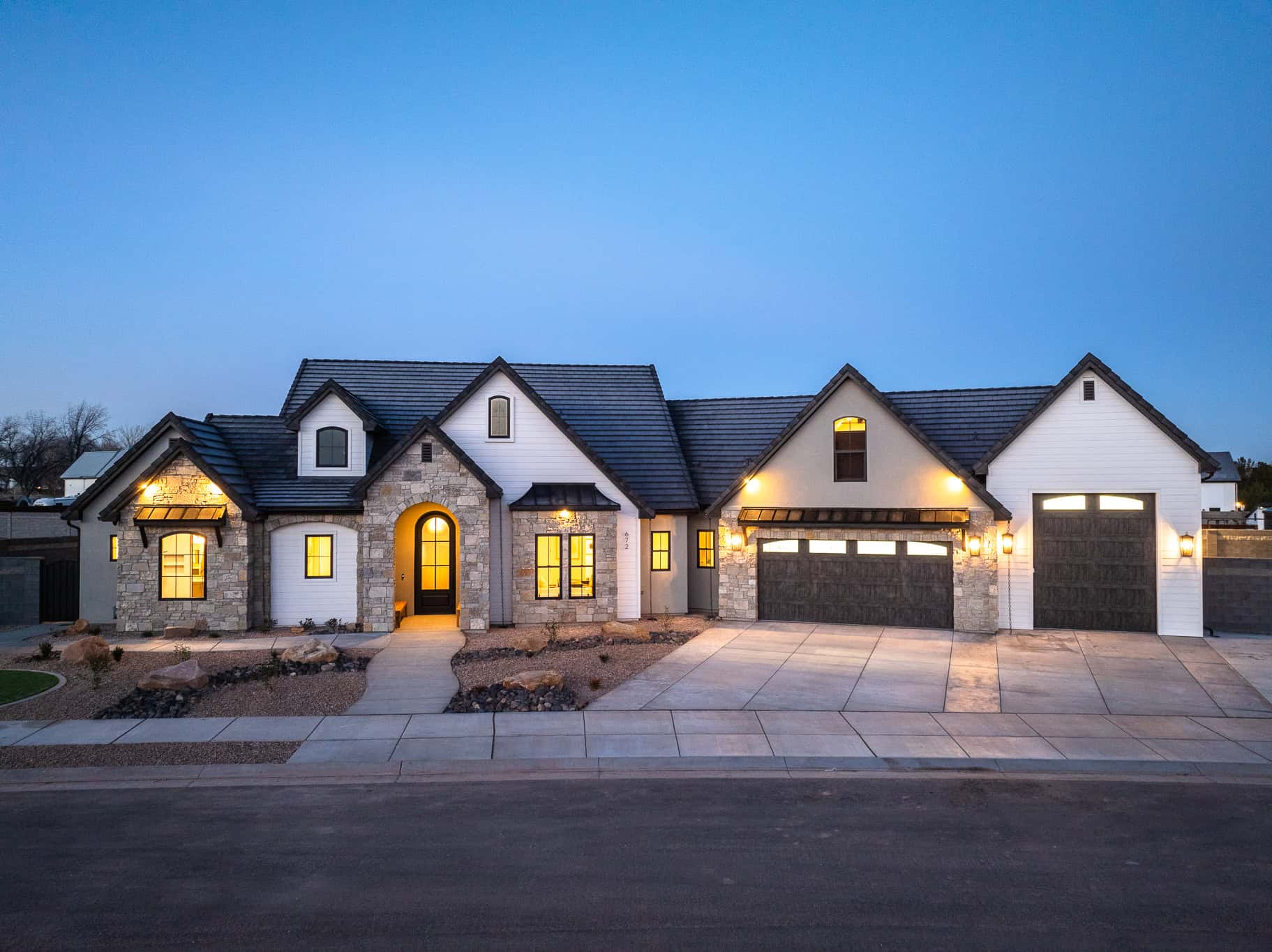 Exterior of large, beautiful home in Utah at Dusk with custom arched windows