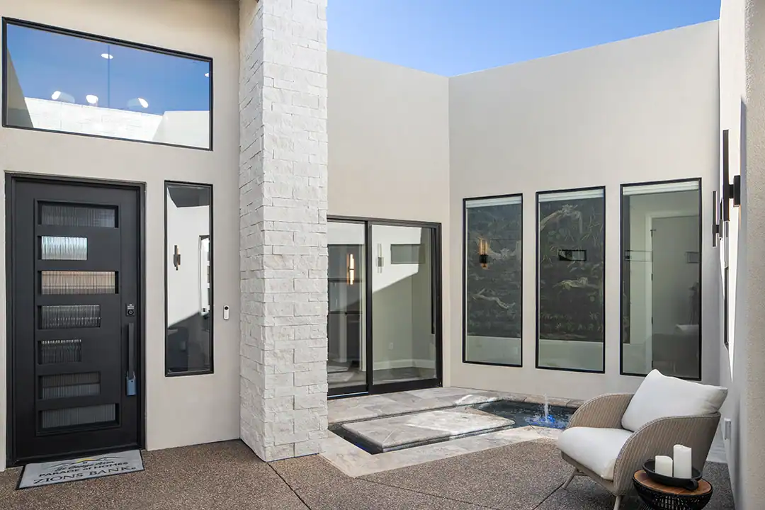 Home entry patio with a black door and beautiful windows with black frames