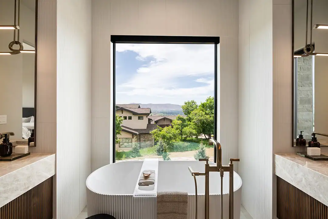 Large modern bathroom with a vast picture window behind a garden bathtub